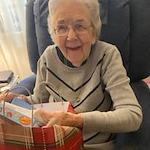 Ascension Living Via Christi Village Georgetown Senior Independent Living in Wichita, Kansas resident opening a Christmas gift