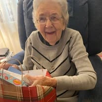 Ascension Living Via Christi Village Georgetown Senior Independent Living in Wichita, Kansas resident opening a Christmas gift