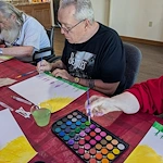 Seniors in assisted living and memory care at Charter Senior Living of Hasmer Lake in Jackson, WI, painting together and embracing creativity through group art activities.
