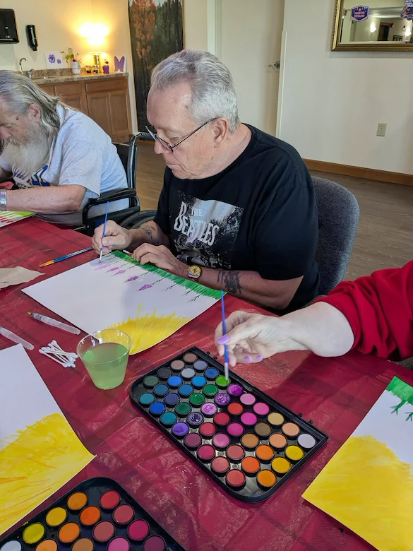 Seniors in assisted living and memory care at Charter Senior Living of Hasmer Lake in Jackson, WI, painting together and embracing creativity through group art activities.