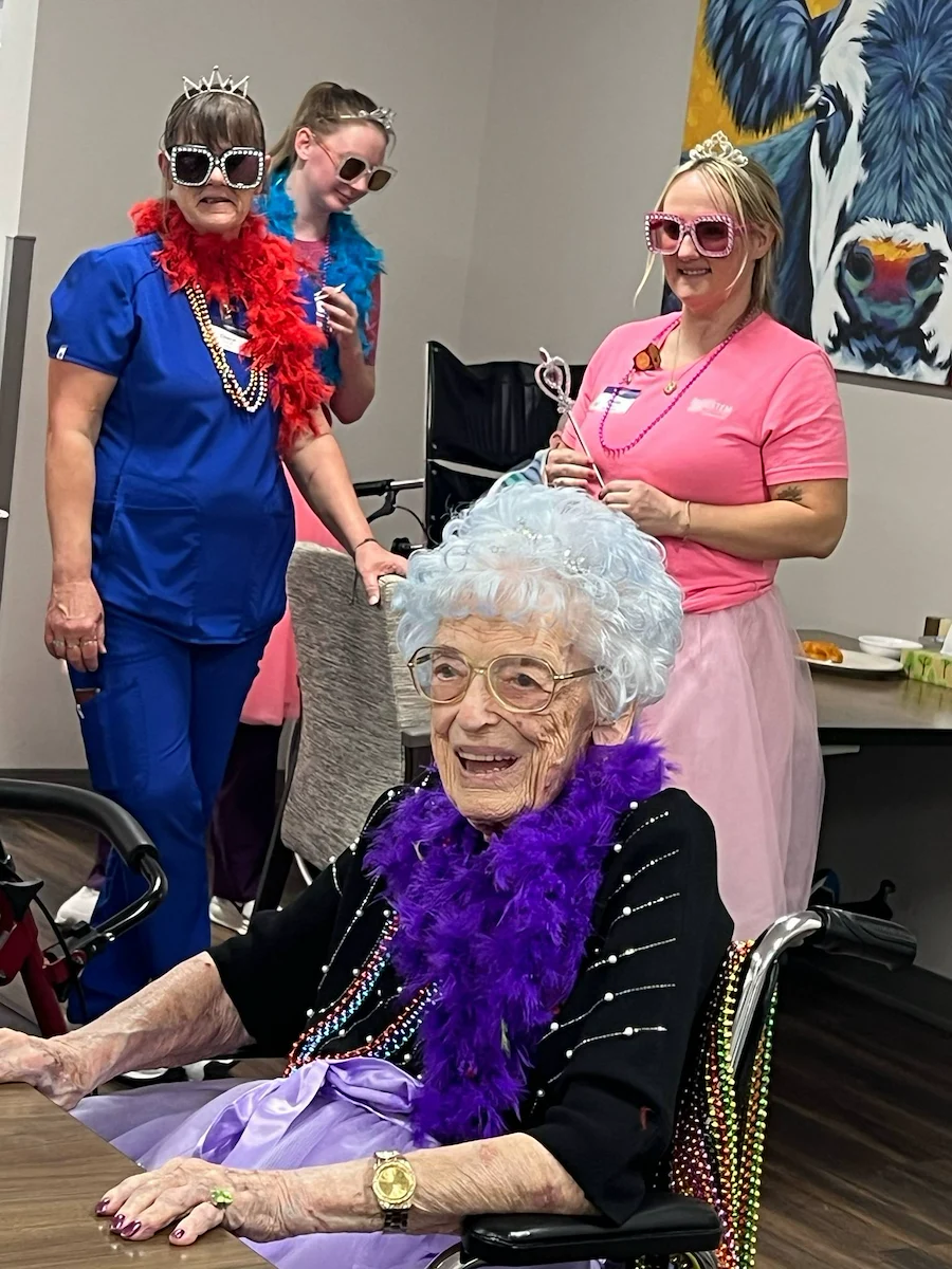Kidron Bethel Village senior living community and continuing care retirement community (CCRC) offering independent living, assisted living, and respite care in North Newton, KS, smiling resident wearing a boa at a celebration