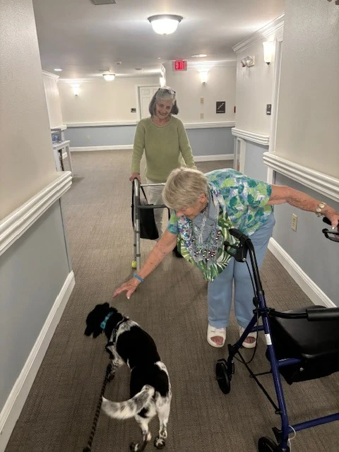 Charter Senior Living of Charlotte resident enjoys the visit from a dog