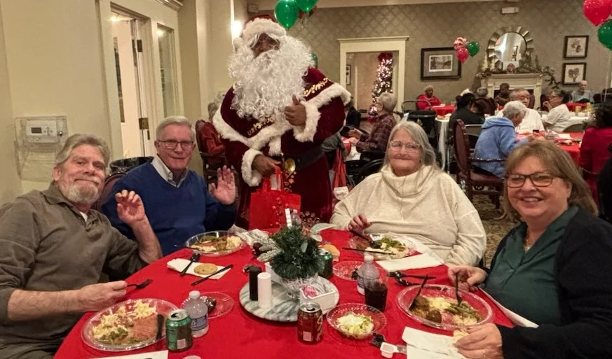 American House Elmwood, senior living community offering independent living, assisted living, memory care, and respite care in Rochester Hills, MI, residents eating Christmas dinner with Santa Clause