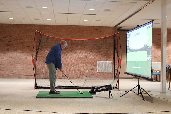 Porter Hills Village resident activity - golfing on a simulator