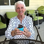 Faith Cottages Memory Care Basehor, KS, happy resident with plant from a community activity