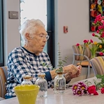 Fieldstone on Clear Creek resident enjoys floral arrangement activity