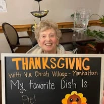 Ascension Living Via Christi Village Manhattan Senior Living in Manhattan, Kansas resident holding a Thanksgiving sign