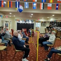 Magnolia Heights Gracious Retirement Living Hawthorn Senior Independent Living in Franklin, Massachusetts residents playing volleyball inside with a beach ball