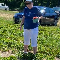 Ashton Gardens Gracious Retirement Living Hawthorn Senior Living Community in Portland, Maine resident picking strawberries