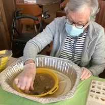Colonial Gardens Gracious Retirement Living Hawthorn Senior Independent Living in Beverly, Massachusetts resident doing a geode finding activity