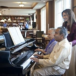Allegro Hyde Park, senior living community offering independent living, assisted living, and respite care in Tampa, FL, residents playing piano together
