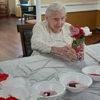 Ascension Living Via Christi Village Ponca City Senior Living in Ponca City, Oklahoma resident looking at Valentine's Day craft