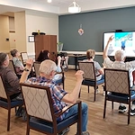 Cascade Creek Memory Care residents performing an activity in the media room.