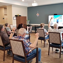 Cascade Creek Memory Care residents performing an activity in the media room.