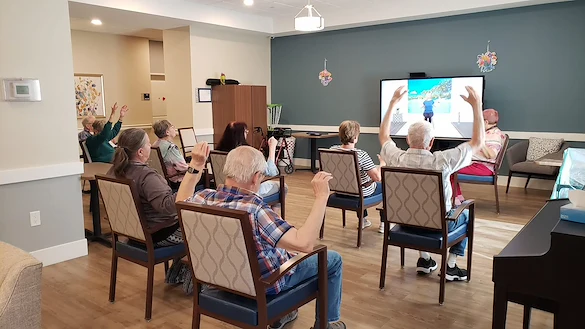 Cascade Creek Memory Care residents performing an activity in the media room.