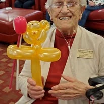 Magnolia Heights Gracious Retirement Living Hawthorn Senior Independent Living in Franklin, Massachusetts resident holding a balloon animal