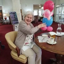 Summerville Estates Gracious Retirement Living Hawthorn Senior Independent Living in Summerville, South Carolina residents holding a balloon animal