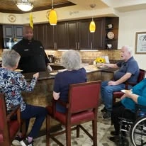 Maple Ridge Gracious Retirement Living Hawthorn Senior Independent Living in Cedar Park, Texas residents socializing with a staff member in the kitchen