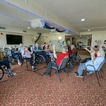 Seniors in assisted living and memory care at Charter Senior Living of Hasmer Lake in Jackson, WI, playing indoor balloon volleyball, promoting active lifestyles and social engagement.