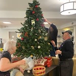 Avamere at Sandy senior living community offering assisted living, memory care, and respite care in Sandy, OR, residents decorating a Christmas tree