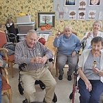Wesley Manor Assisted Living Community offering assisted living and continuing care retirement community (CCRC) services in Louisville, KY, smiling residents spending time together and holding up tiny trophies