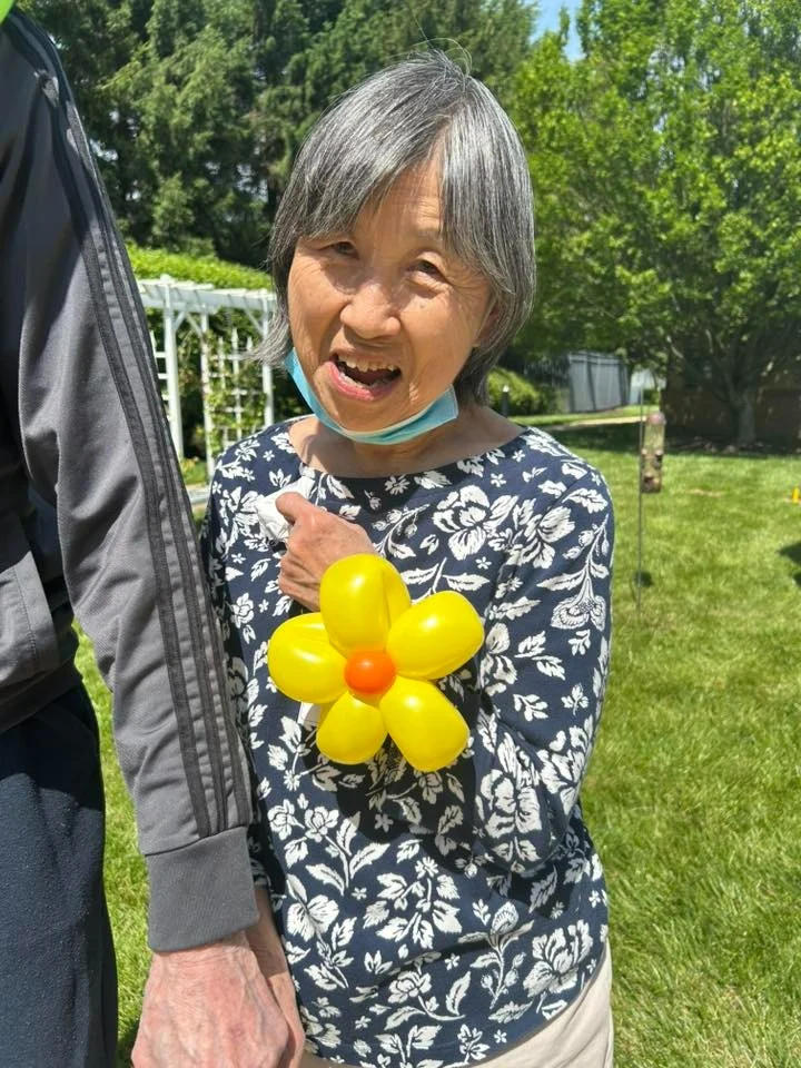 Charter Senior Living of Columbia smiling resident with balloon creation