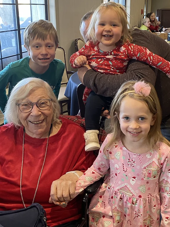 American House Stone senior living community offering independent living and respite care in Rochester Hills, MI, smiling resident enjoying a visit from little kids