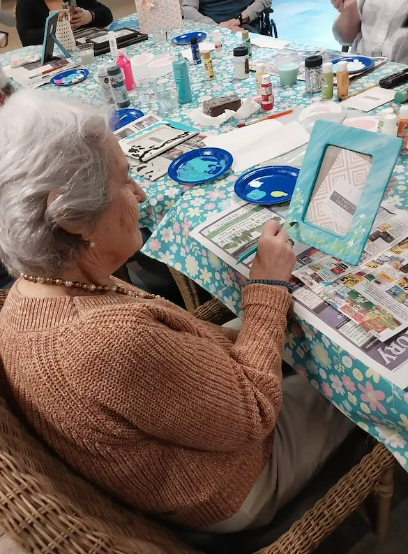 Fieldstone Memory Care of Yakima resident having fun with a painting activity