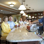 Allegro Hyde Park, senior living community offering independent living, assisted living, and respite care in Tampa, FL, residents enjoying a happy hour and good company