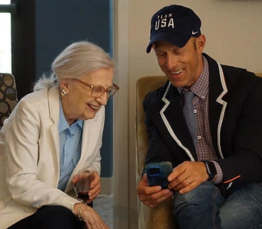 Sage Independence residents laughing at a cell phone