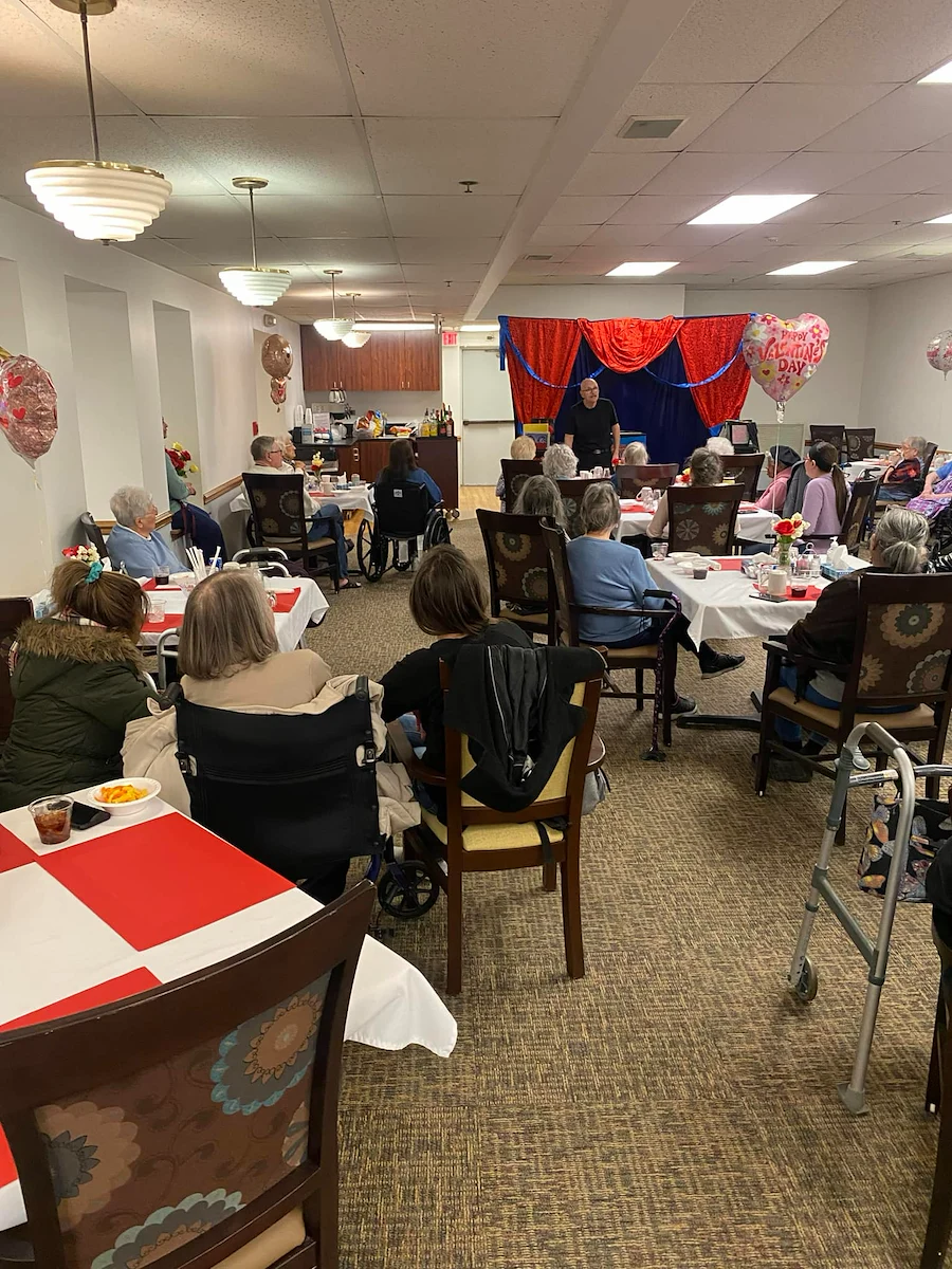 Prime Healthcare Senior Living – Fox Knoll Village in Aurora, IL, residents enjoy an entertaining performance from a magician