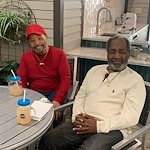 Two seniors at Charter Senior Living of Hazel Crest in Hazel Crest, IL, smiling and enjoying lemonade together, sharing a moment of friendship and refreshment in assisted living and memory care.