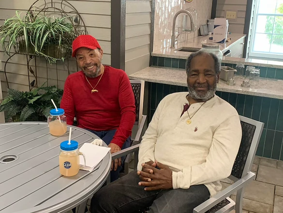 Two seniors at Charter Senior Living of Hazel Crest in Hazel Crest, IL, smiling and enjoying lemonade together, sharing a moment of friendship and refreshment in assisted living and memory care.