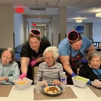 Ascension Living Bethlehem Woods Village senior living community offering independent living, assisted living, and memory care in La Grange Park, IL, residents trying new food at a cultural event