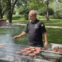 Ascension Casa Scalabrini Senior Living, independent senior living community in Northlake, IL, staff member grilling burgers outside