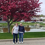 Cascade Creek Memory Care residents hugging in front of a pond for a photo