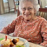Charter Memory Care of Moline resident smiles with treats