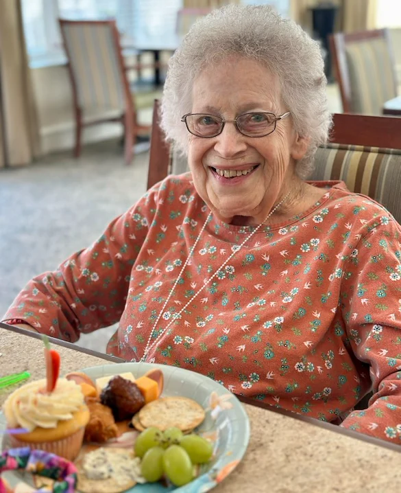 Charter Memory Care of Moline resident smiles with treats