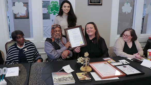 American House Dearborn Heights, senior living community offering independent living and respite care in Dearborn Heights, MI, resident smiling and receiving recognition