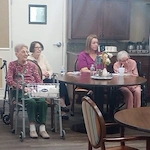 American House Sterling Heights, senior living community offering independent living and respite care in Sterling Heights, MI, residents sitting together with a staff member