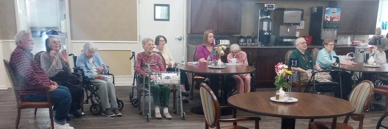 American House Sterling Heights, senior living community offering independent living and respite care in Sterling Heights, MI, residents sitting together with a staff member