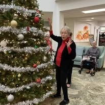 The Highlands Gracious Retirement Living Hawthorn Senior Independent Living in Westborough, Massachusetts resident decorating a Christmas tree