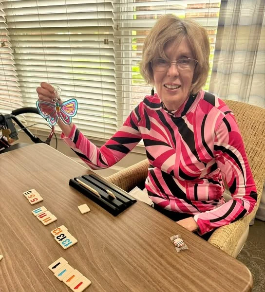 The Forum at The Crossing happy resident with a craft and playing a game