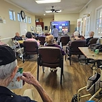 Aberdeen Crossings by New Perspective, senior living community offering assisted living in Highland Heights, OH, residents engaged in a presentation
