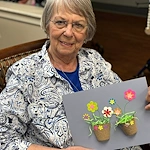 Charter Senior Living of Bowling Green resident smiles with craft
