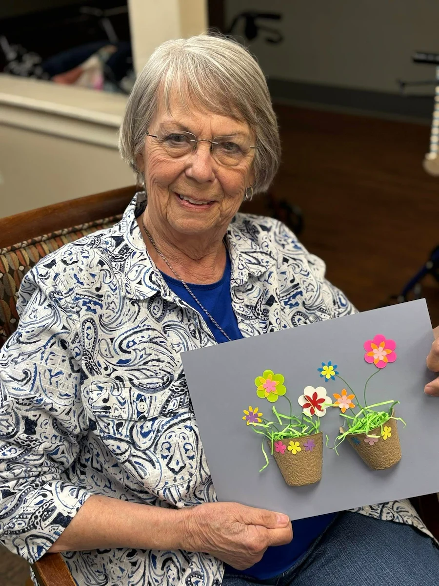 Charter Senior Living of Bowling Green resident smiles with craft