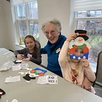 The Highlands Gracious Retirement Living Hawthorn Senior Independent Living in Westborough, Massachusetts resident making a snowman craft with kids