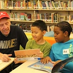 Chelsea Place Memory Care resident reading with children