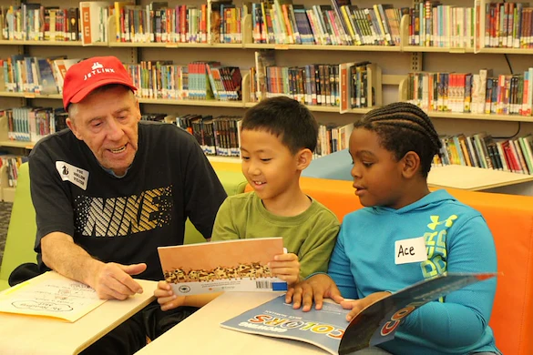 Chelsea Place Memory Care resident reading with children