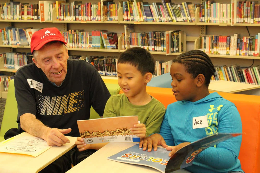 Chelsea Place Memory Care resident reading with children